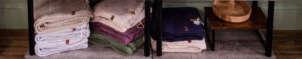 Stacks of soft hand-knit baby blankets by Laura Kumpula